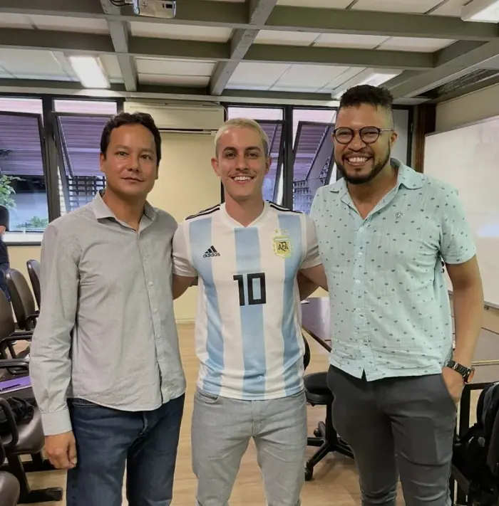Felipe com dois colegas numa sala de aula
