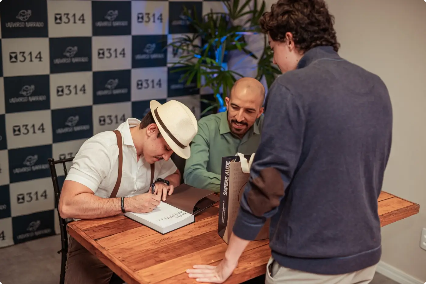 Os dois autores autografando exemplares lado a lado